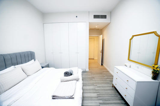 Minimalist bedroom with a neutral color palette, white storage cabinets, and a neatly made bed, creating a calm and clutter-free space for mindful living.